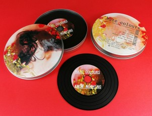 Black vinyl CDs in printed metal tins